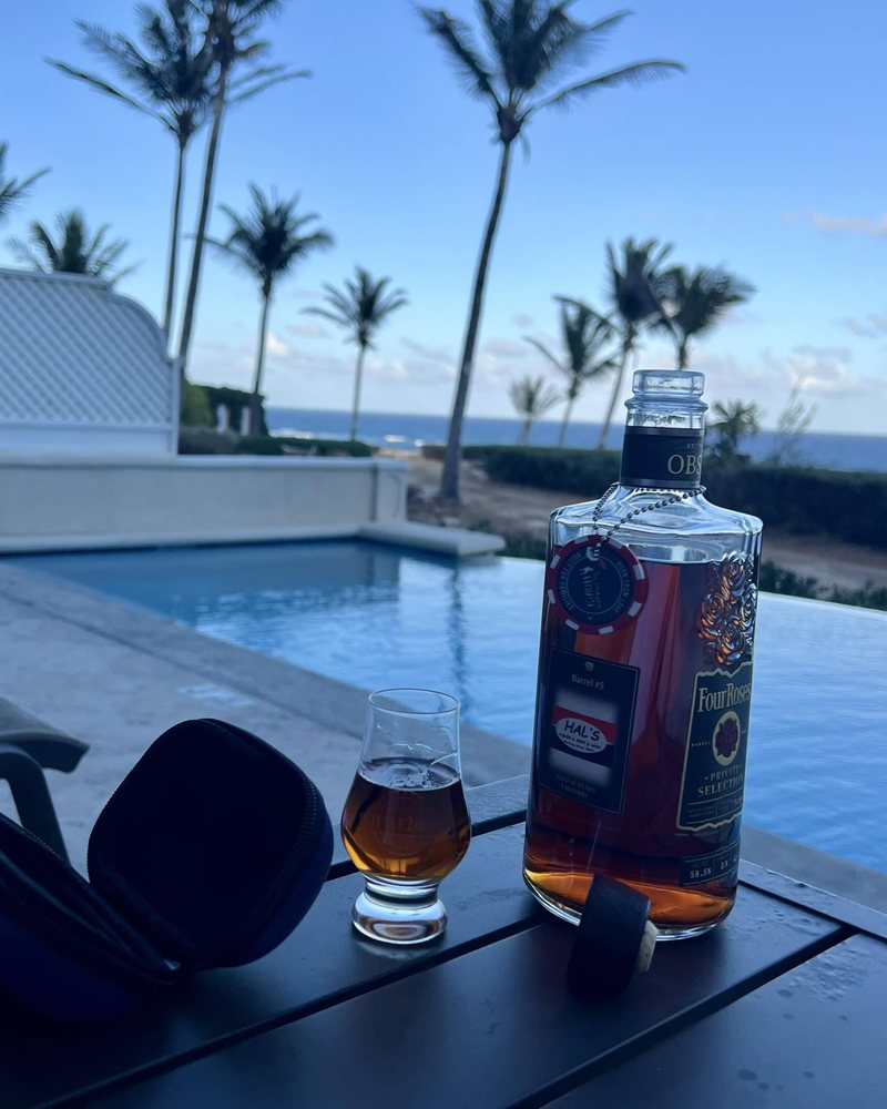 Bottle2Bond travel whiskey glass and a bourbon bottle poolside on a trip